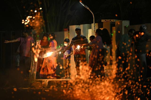 TOPSHOT - People light firecrackers during the Diwali, a Hindu festival of lights, in Bengaluru on October 20, 2025. (Photo by Idrees MOHAMMED / AFP)