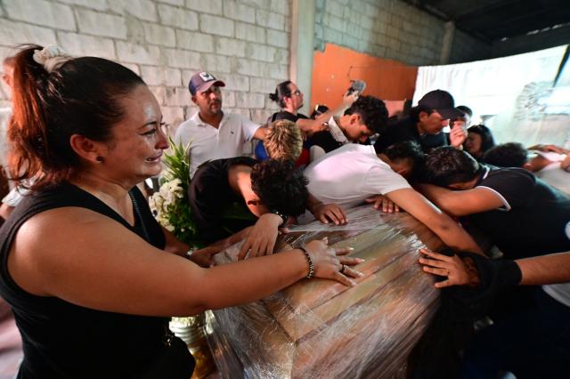 (FILES) Football teammates of Ismael Arroyo, 15, mourn around his coffin during his wake and that of his brother Josue, 14, two of the four minors who had been missing for three weeks since disappearing during a military operation while playing football, in Guayaquil, Ecuador, on January 1, 2025. Since 2023, when President Daniel Noboa took office, Amnesty International has documented 43 cases of enforced disappearances carried out by state agents in Ecuador. (Photo by Marcos PIN / AFP)