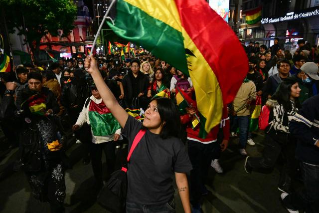 A demonstrator holds a Bolivian flag during a protest against president-elect Rodrigo Paz following the results of the run-off presidential election in La Paz on October 20, 2025. Paz, a 58-year-old economist, won Sunday's election with 54.5% of the counted votes, ahead of right-wing former president Jorge Quiroga, who received 45.4%, according to the official tally. He is set to take office on November 8. (Photo by MARTIN BERNETTI / AFP)