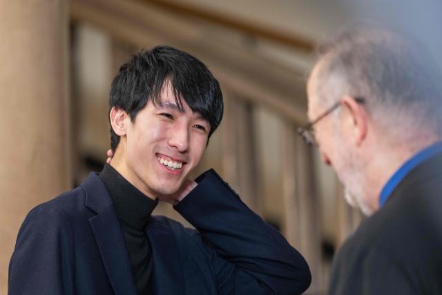 The winner of the 19th International Chopin Piano Competition Eric Lu of the US smiles as he speaks with the head of the jury Garrick Ohlsson (R) after the results were announced in Warsaw on October 21, 2025. (Photo by Wojtek RADWANSKI / AFP)