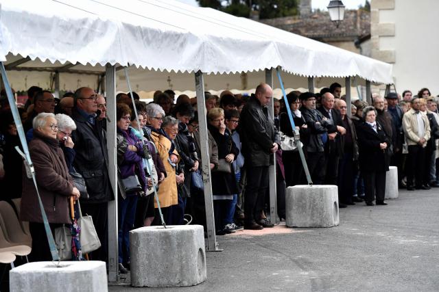 (FILES) People pay their respects on October 23, 2016 in Petit-Palais-et-Cornemp after the mayor unveiled a stele engraved with the victims' names, during a ceremony marking the one year anniversary of France's deadliest road accident in over three decades, that killed 43 people last year near Puisseguin. A tribute ceremony dedicated to the 43 victims will take place on October 23, 2025, ten years after the bus accident in Puisseguin, as the criminal proceeding has come to a standstill. (Photo by GEORGES GOBET / AFP)