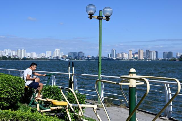 A man exercises by West Lake in Hanoi on October 21, 2025. (Photo by Nhac NGUYEN / AFP)