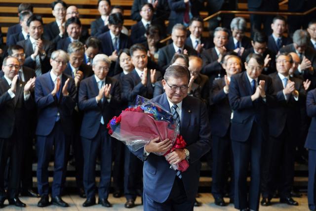 Japan's outgoing Prime Minister Shigeru Ishiba (C) leaves the prime minister's office on his final day as the Japanese leader in Tokyo on October 21, 2025.  (Photo by Kazuhiro NOGI / AFP)