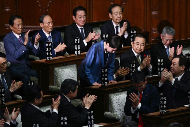 Liberal Democratic Party (LDP) President Sanae Takaichi stands up and bows to acknowledge the applause after she was selected as Japan's new prime minister during an extraordinary session of the lower house of parliament in Tokyo on October 21, 2025.  (Photo by Philip FONG / AFP)