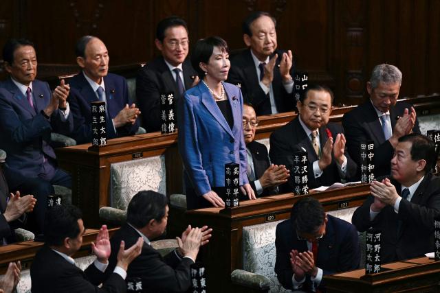 Liberal Democratic Party (LDP) President Sanae Takaichi stands up to acknowledge the applause after she was selected as Japan's new prime minister during an extraordinary session of the lower house of parliament in Tokyo on October 21, 2025.  (Photo by Philip FONG / AFP)