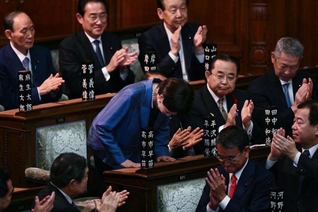 Liberal Democratic Party (LDP) President Sanae Takaichi stands up and bows to acknowledge the applause after she was selected as Japan's new prime minister during an extraordinary session of the lower house of parliament in Tokyo on October 21, 2025.  (Photo by Philip FONG / AFP)