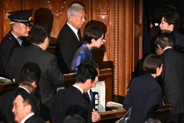 Liberal Democratic Party (LDP) President Sanae Takaichi (C, in blue) leaves after she was selected as Japan's new prime minister during an extraordinary session of the lower house of parliament in Tokyo on October 21, 2025.  (Photo by Philip FONG / AFP)