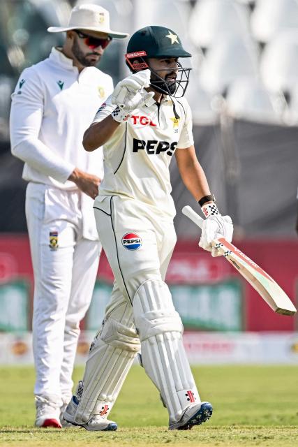 Pakistan's Saud Shakeel (R) celebrates after scoring a half-century (50 runs) during the second day of the second Test cricket match between Pakistan and South Africa at the Rawalpindi Cricket Stadium in Rawalpindi on October 21, 2025. (Photo by Aamir QURESHI / AFP)
