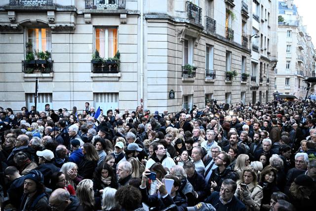 Supporters of France's former president Nicolas Sarkozy gather outside his residence ahead of his departure to La Sante prison for incarceration on a five-year prison sentence, after being convicted of criminal conspiracy over a plan for late Libyan dictator Moamer Kadhafi to fund his 2007 electoral campaign, in Paris, on October 21, 2025. Nicolas Sarkozy, who has faced a flurry of legal woes since losing re-election in 2012, is to be jailed on October 21, 2025, over a scheme to acquire Libyan funding for his successful 2007 presidential run, becoming the first former head of a European Union country to serve time behind bars. The former French right-wing leader has appealed the verdict and denounced an "injustice". (Photo by JULIEN DE ROSA / AFP)