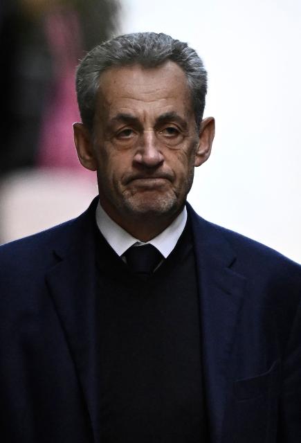TOPSHOT - France's former president Nicolas Sarkozy leaves his residence to present himself to La Sante Prison for incarceration on a five-year prison sentence after being convicted of criminal conspiracy over a plan for late Libyan dictator Moamer Kadhafi to fund his 2007 electoral campaign, in Paris, on October 21, 2025. Nicolas Sarkozy, who has faced a flurry of legal woes since losing re-election in 2012, is to be jailed on October 21, 2025, over a scheme to acquire Libyan funding for his successful 2007 presidential run, becoming the first former head of a European Union country to serve time behind bars. The former French right-wing leader has appealed the verdict and denounced an "injustice". (Photo by JULIEN DE ROSA / AFP)