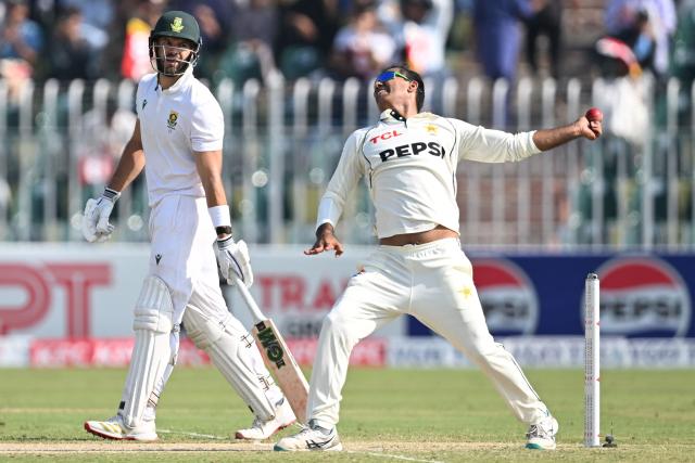 Pakistan's Noman Ali (R) bowls as South Africa's captain Aiden Markram watches during the second day of the second Test cricket match between Pakistan and South Africa at the Rawalpindi Cricket Stadium in Rawalpindi on October 21, 2025. (Photo by Aamir QURESHI / AFP)
