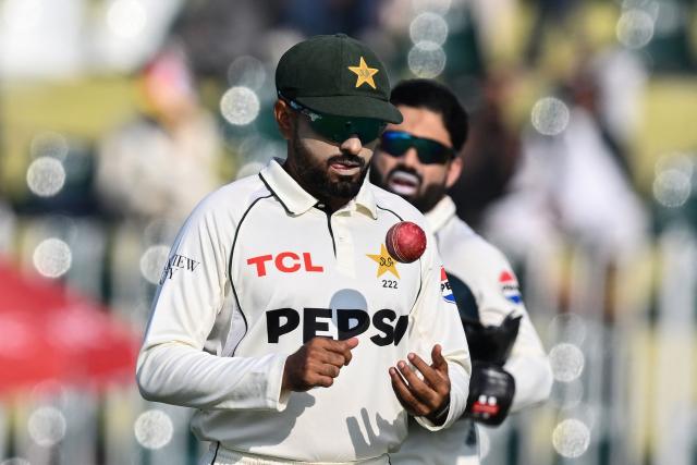Pakistan's Babar Azam tosses the ball during the second day of the second Test cricket match between Pakistan and South Africa at the Rawalpindi Cricket Stadium in Rawalpindi on October 21, 2025. (Photo by Aamir QURESHI / AFP)