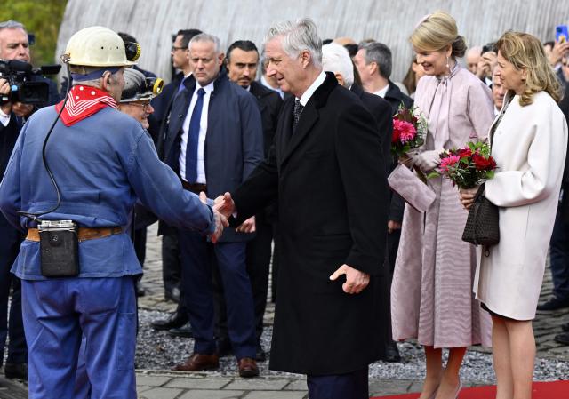 King Philippe - Filip of Belgium, Queen Mathilde of Belgium and Italian President's daughter Laura Mattarella greet miners as they visit the Le Bois du Cazier industrial heritage site and former coal mine, in Marcinelle, on October 21, 2025 on the second day of the official state visit of the Italian President. The Italian President and his daughter are on an official state visit to Belgium from 20 to 22 October 2025. (Photo by ERIC LALMAND / Belga / AFP) / Belgium OUT