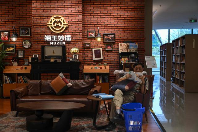 A man reads a book at a bookstore in Shenzhen, in southern China's Guangdong province on October 21, 2025. (Photo by Jade GAO / AFP)