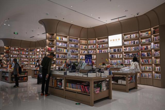 People read books at a bookstore in Shenzhen, in southern China's Guangdong province on October 21, 2025. (Photo by Jade GAO / AFP)