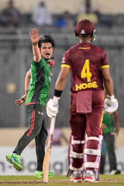 Bangladesh's Nasum Ahmed (L) celebrates after taking the wicket of West Indies' Roston Chase during the second one-day international (ODI) cricket match between Bangladesh and West Indies at the Sher-e-Bangla National Cricket Stadium in Dhaka on October 21, 2025. (Photo by Munir UZ ZAMAN / AFP)