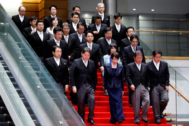 Japan's new Prime Minister Sanae Takaichi (C, front row) arrives for a photo session with members of her cabinet at the prime minister's office in Tokyo on October 21, 2025. (Photo by Kiyoshi Ota / POOL / AFP)