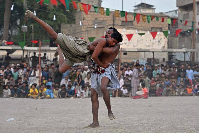 Wrestlers compete in a 'Sindhi Malakhra' wrestling match, an ancient form of wrestling that originated in Pakistan's Sindh region, during a local tournament in Karachi on October 21, 2025. (Photo by Asif HASSAN / AFP)