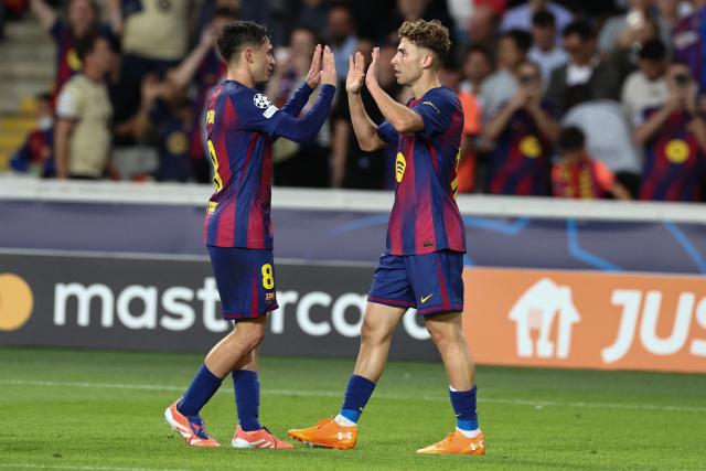 Barcelona's Spanish midfielder #16 Fermin Lopez (R) celebrates with teammate Barcelona's Spanish midfielder #08 Pedri after scoring their second goal during the UEFA Champions League league phase match-day 3 football match between FC Barcelona and Olympiakos FC at Estadi Olimpic Lluis Companys in Barcelona on October 21, 2025. (Photo by Josep LAGO / AFP)