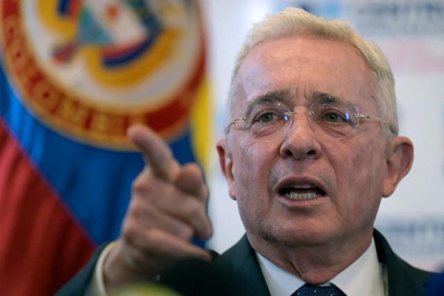 (FILES) Colombian former president (20022010) Alvaro Uribe gestures as he speaks during a press conference after testifying over a 1997 massacre at the Attorney General's Office in Bogota, on November 27, 2023. A Colombian court on October 21, 2025, overturned the witness tampering conviction of influential ex-president Alvaro Uribe, who had been sentenced to 12 years' house arrest in a decision condemned by the United States. The 73-year-old, who led a relentless military campaign against drug cartels and leftist guerillas as president from 2002 to 2010, had been found guilty of asking right-wing paramilitaries to lie about their alleged links to him. (Photo by Juan BARRETO / AFP)