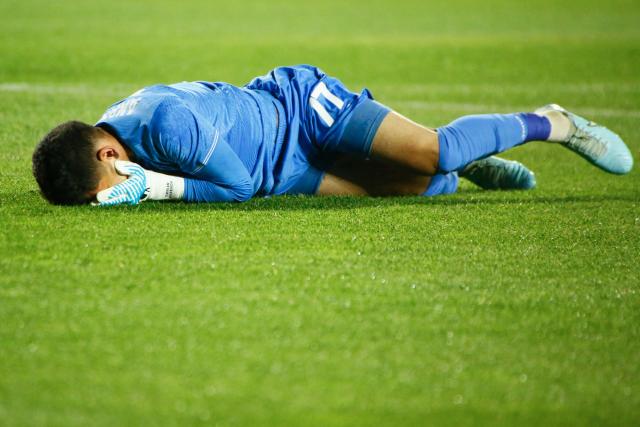 Kairat Almaty's Kazakh goalkeeper #77 Temirlan Anarbekov reacts lying on the pitch during the UEFA Champions League football match between Kairat Almaty and Pafos at the Almaty Ortalyk stadion in Almaty on October 21, 2025. (Photo by Ruslan PRYANIKOV / AFP)