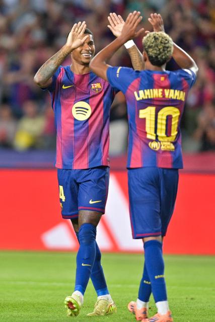 Barcelona's English forward #14 Marcus Rashford celebrates with Barcelona's Spanish forward #10 Lamine Yamal after scoring their fourth goal during the UEFA Champions League league phase match-day 3 football match between FC Barcelona and Olympiakos FC at Estadi Olimpic Lluis Companys in Barcelona on October 21, 2025. (Photo by MANAURE QUINTERO / AFP)