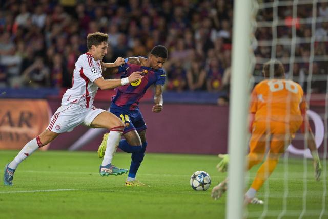 Barcelona's English forward #14 Marcus Rashford (C) vies for the ball with Olympiakos' Greek defender #45 Panagiotis Retsos during the UEFA Champions League league phase match-day 3 football match between FC Barcelona and Olympiakos FC at Estadi Olimpic Lluis Companys in Barcelona on October 21, 2025. (Photo by MANAURE QUINTERO / AFP)
