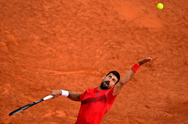 TOPSHOT - (FILES) Serbia's Novak Djokovic serves to Italy's Jannik Sinner during their men's singles semi-final match on day 13 of the French Open tennis tournament on Court Philippe-Chatrier at the Roland-Garros Complex in Paris on June 6, 2025. Tennisman Novak Djokovic has announced his withdrawal from the Paris Masters 1000 on Instagram on October 21, 2025. (Photo by JULIEN DE ROSA / AFP)