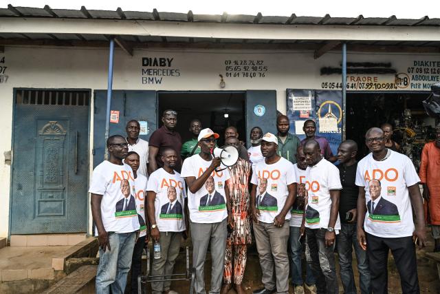 Supporters, wearing t-shirts bearing the portrait of Ivorian President Alassane Ouattara, and presidential candidate of the Rally of Houphouetists for Democracy and Peace (RHDP), campaign for the upcoming presidential election, in Abobo, northern suburb of Abidjan, on October 21, 2025. The presidential election in Ivory Coast will be held on October 25, 2025, (Photo by Sia KAMBOU / AFP)