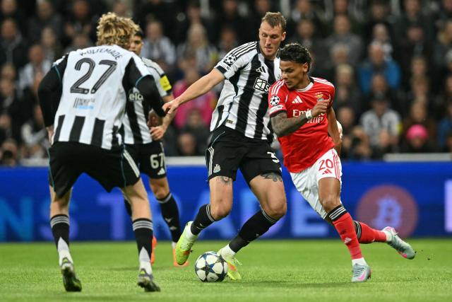 Benfica's Colombian midfielder #20 Richard Rios (R) vies with Newcastle United's English defender #33 Dan Burn (C) during the English Premier League football match between Newcastle United and Benfica at St James' Park in Newcastle-upon-Tyne, north east England on October 21, 2025. (Photo by ANDY BUCHANAN / AFP)