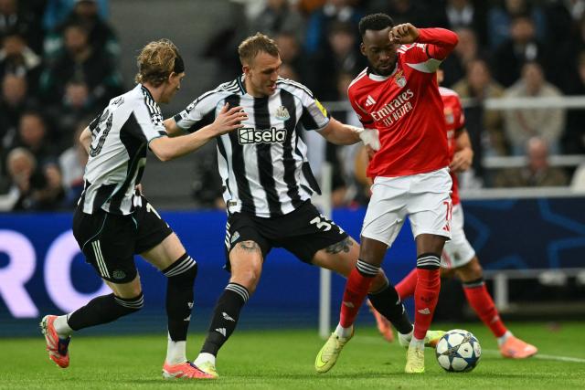 Newcastle United's English defender #33 Dan Burn (C) vies with Benfica's Belgian midfielder #11 Dodi Lukébakio (R) during the English Premier League football match between Newcastle United and Benfica at St James' Park in Newcastle-upon-Tyne, north east England on October 21, 2025. (Photo by ANDY BUCHANAN / AFP)