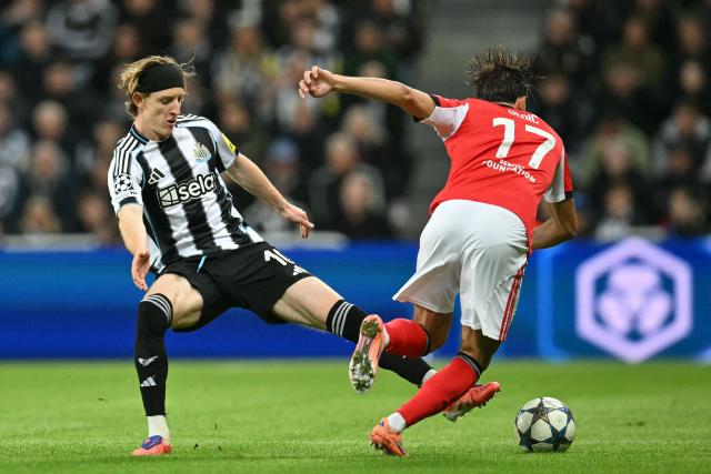 Newcastle United's English midfielder #10 Anthony Gordon (L) vies with Benfica's Bosnian defender #17 Amar Dedic (R) during the English Premier League football match between Newcastle United and Benfica at St James' Park in Newcastle-upon-Tyne, north east England on October 21, 2025. (Photo by ANDY BUCHANAN / AFP)