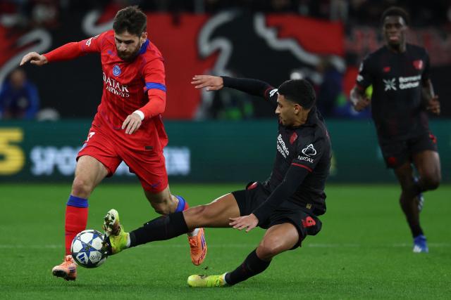 Paris Saint-Germain's Georgian forward #07 Khvicha Kvaratskhelia (L) and Bayer Leverkusen's Argentinian midfielder #06 Ezequiel Fernandez vie for the ball during the UEFA Champions League football match between Bayer 04 Leverkusen and Paris Saint-Germain (PSG) at the BayArena stadium in Leverkusen, western Germany on October 21, 2025. (Photo by FRANCK FIFE / AFP)