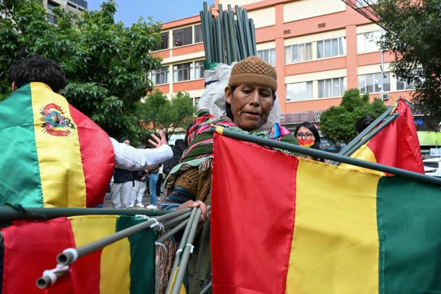 A woman sells Bolivian flags during a protest by supporters of Bolivia's former president and presidential candidate for the Freedom and Democracy (Libre) alliance, Jorge "Tuto" Quiroga, demanding a vote audit by the Supreme Electoral Tribunal (TSE) following the presidential election, in La Paz on October 21, 2025. Rodrigo Paz, a 58-year-old economist, won the second round of voting on October 19 with 54.5 percent of the votes against former right-wing president Jorge Quiroga. (Photo by AIZAR RALDES / AFP)