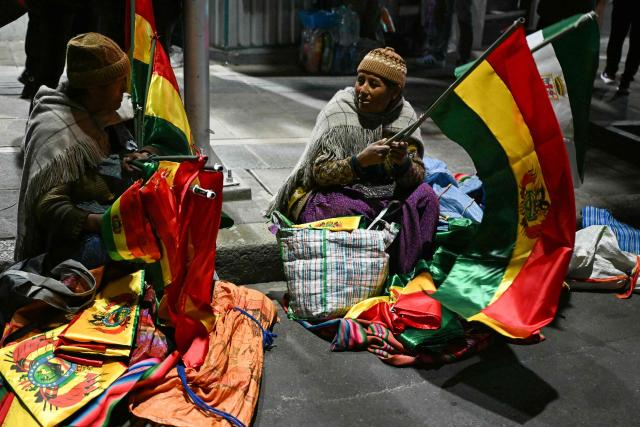 Women sell Bolivian flags during a protest by supporters of Bolivia's former president and presidential candidate for the Freedom and Democracy (Libre) alliance, Jorge "Tuto" Quiroga, demanding a vote audit by the Supreme Electoral Tribunal (TSE) following the presidential election, in La Paz on October 21, 2025. Rodrigo Paz, a 58-year-old economist, won the second round of voting on October 19 with 54.5 percent of the votes against former right-wing president Jorge Quiroga. (Photo by AIZAR RALDES / AFP)