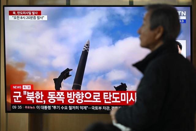 A man walks past a television screen showing a news broadcast with file footage of a North Korean missile test, at a train station in Seoul on October 22, 2025. North Korea fired at least one ballistic missile on October 22, Seoul's military said, its first such launch in months. (Photo by Jung Yeon-je / AFP)