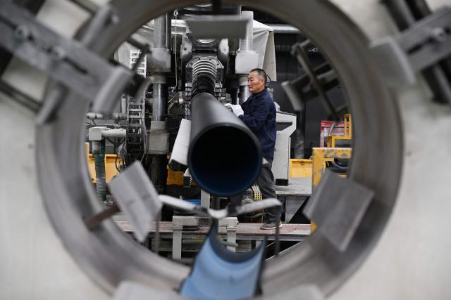An employee works on the production line of polyethylene pipes at a factory in Suqian, in eastern China's Jiangsu province on October 21, 2025. (Photo by AFP) / China OUT