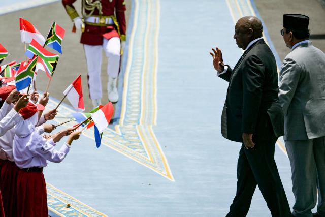 South Africa’s President Cyril Ramaphosa (L) react after inspecting an honour guard with Indonesia’s President Prabowo Subianto (R) before their bilateral meeting at the presidential palace in Jakarta on October 22, 2025. (Photo by Bay ISMOYO / AFP)