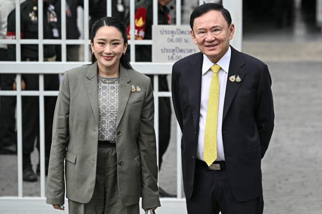 (FILES) Thailand's former Prime Minister Thaksin Shinawatra poses with his daughter Thailand's sacked prime minister Paetongtarn Shinawatra as they arrive at the Supreme Court in Bangkok on September 9, 2025, ahead of a ruling on whether he properly served a prison term in 2023. Thailand's recently removed prime minister Paetongtarn Shinawatra resigned on October 22, 2025 as leader of the party founded by her father, ex-premier Thaksin, signaling the potential end of the family's decades-long political dynasty. (Photo by Lillian SUWANRUMPHA / AFP)