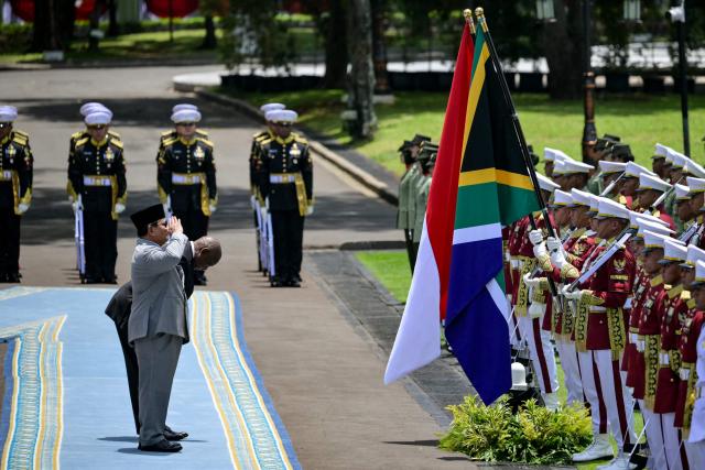 Indonesia’s President Prabowo Subianto (front) and South Africa’s President Cyril Ramaphosa inspect an honour guard before their bilateral meeting at the presidential palace in Jakarta on October 22, 2025. (Photo by Bay ISMOYO / AFP)