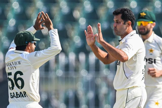 Pakistan's Asif Afridi (R) celebrates with Babar Azam after taking the wicket of South Africa's Tristan Stubbs during the third day of the second Test cricket match between Pakistan and South Africa at the Rawalpindi Cricket Stadium in Rawalpindi on October 22, 2025. (Photo by Aamir QURESHI / AFP)