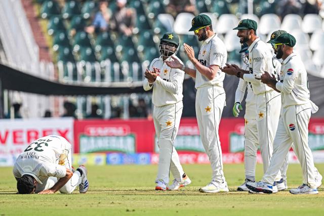 Pakistan's Asif Afridi (L) bows to pray as he celebrates with teammates after taking his fifth wicket of South Africa's Simon Harmer during the third day of the second Test cricket match between Pakistan and South Africa at the Rawalpindi Cricket Stadium in Rawalpindi on October 22, 2025. (Photo by Aamir QURESHI / AFP)