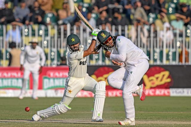 Pakistan's Babar Azam (L) plays a shot as South Africa's Tony de Zorzi reacts during the third day of the second Test cricket match between Pakistan and South Africa at the Rawalpindi Cricket Stadium in Rawalpindi on October 22, 2025. (Photo by Aamir QURESHI / AFP)