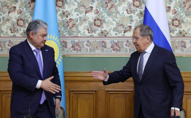 Russian Foreign Minister Sergei Lavrov shakes hands with his Kazakh counterpart Ermek Kosherbayev during a press conference following their talks in Moscow on October 22, 2025. (Photo by Ramil Sitdikov / POOL / AFP)