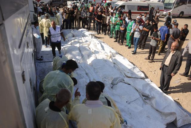 The remains of unidentified Palestinians lie outside Nasser Hospital in Khan Yunis, in the southern Gaza Strip, after their bodies were returned by Israel under a US-brokered ceasefire deal, on October 22, 2025. (Photo by BASHAR TALEB / AFP)