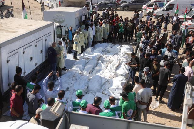 The remains of unidentified Palestinians lie outside Nasser Hospital in Khan Yunis, in the southern Gaza Strip, after their bodies were returned by Israel under a US-brokered ceasefire deal, on October 22, 2025. (Photo by BASHAR TALEB / AFP)