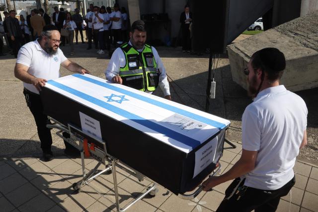 Israeli medical workers prepare the coffin of Thai national Sonthaya Oakkharasri, who killed in the October 7, 2023, attack by Palestinian militants, ahead of a farewell ceremony at the Ben Gurion Airport in Tel Aviv on October 22, 2025, ahead of his flight back to Thailand. (Photo by Jack GUEZ / AFP)