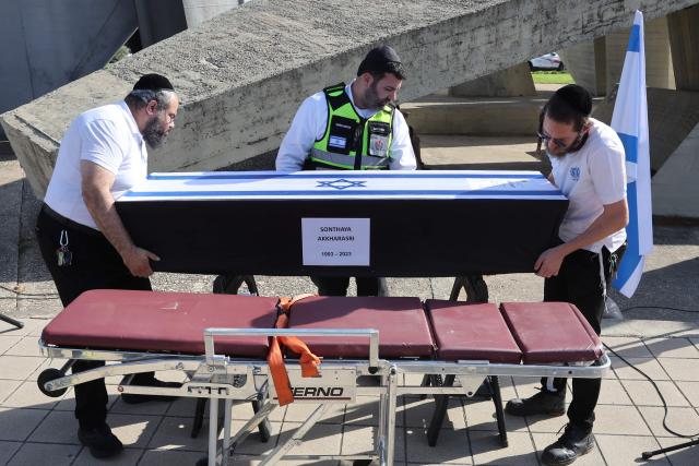 Israeli medical workers prepare the coffin of Thai national Sonthaya Oakkharasri, who killed in the October 7, 2023, attack by Palestinian militants, ahead of a farewell ceremony at the Ben Gurion Airport in Tel Aviv on October 22, 2025, ahead of his flight back to Thailand. (Photo by Jack GUEZ / AFP)