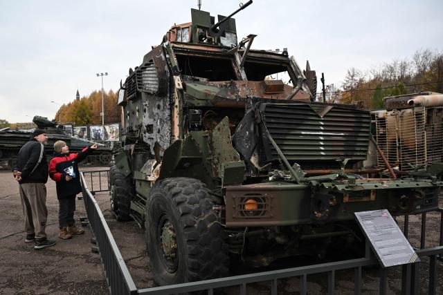 People look at a damaged armoured army vehicle displayed at an exhibition of military equipment captured by Russian forces in Ukraine at the WWII memorial complex in Poklonnaya Hill, in Moscow on October 22, 2025. (Photo by Olesya KURPYAYEVA / AFP)