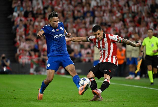 Qarabagh's Colombian forward #17 Camilo Duran and Athletic Bilbao's Spanish defender #17 Yuri Berchiche (R) fight for the ball during the UEFA Champions League league phase day 3 football match between Athletic Club Bilbao and Qarabagh at San Mames Stadium in Bilbao on October 22, 2025. (Photo by ANDER GILLENEA / AFP)